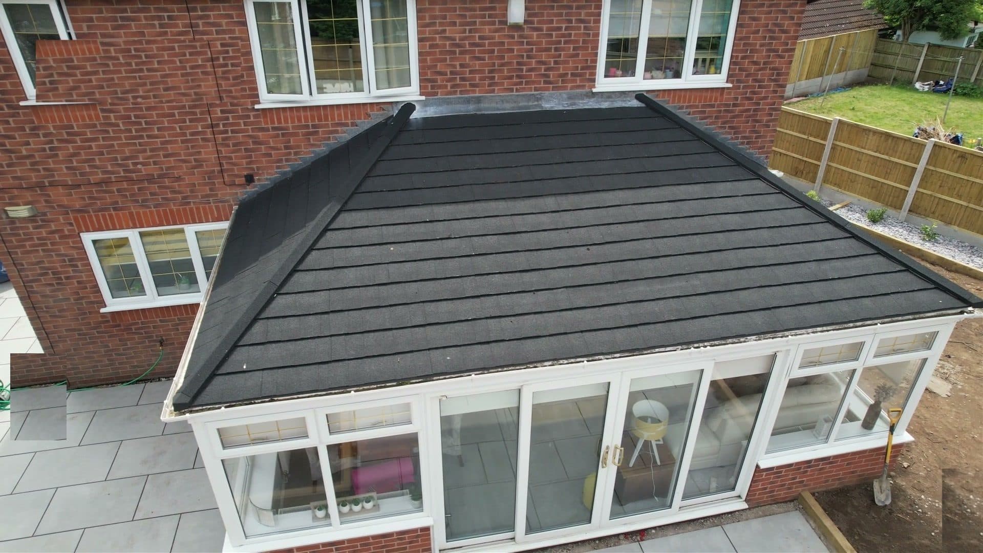 Finished conservatory with a new grey tiled warm roof by WeatherTech Roofing, drone view