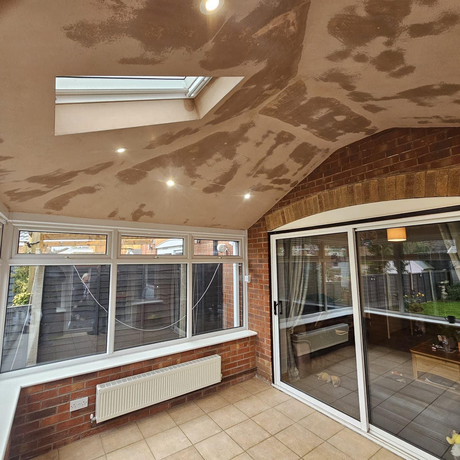 Finished conservatory living space with a vaulted ceiling and large windows