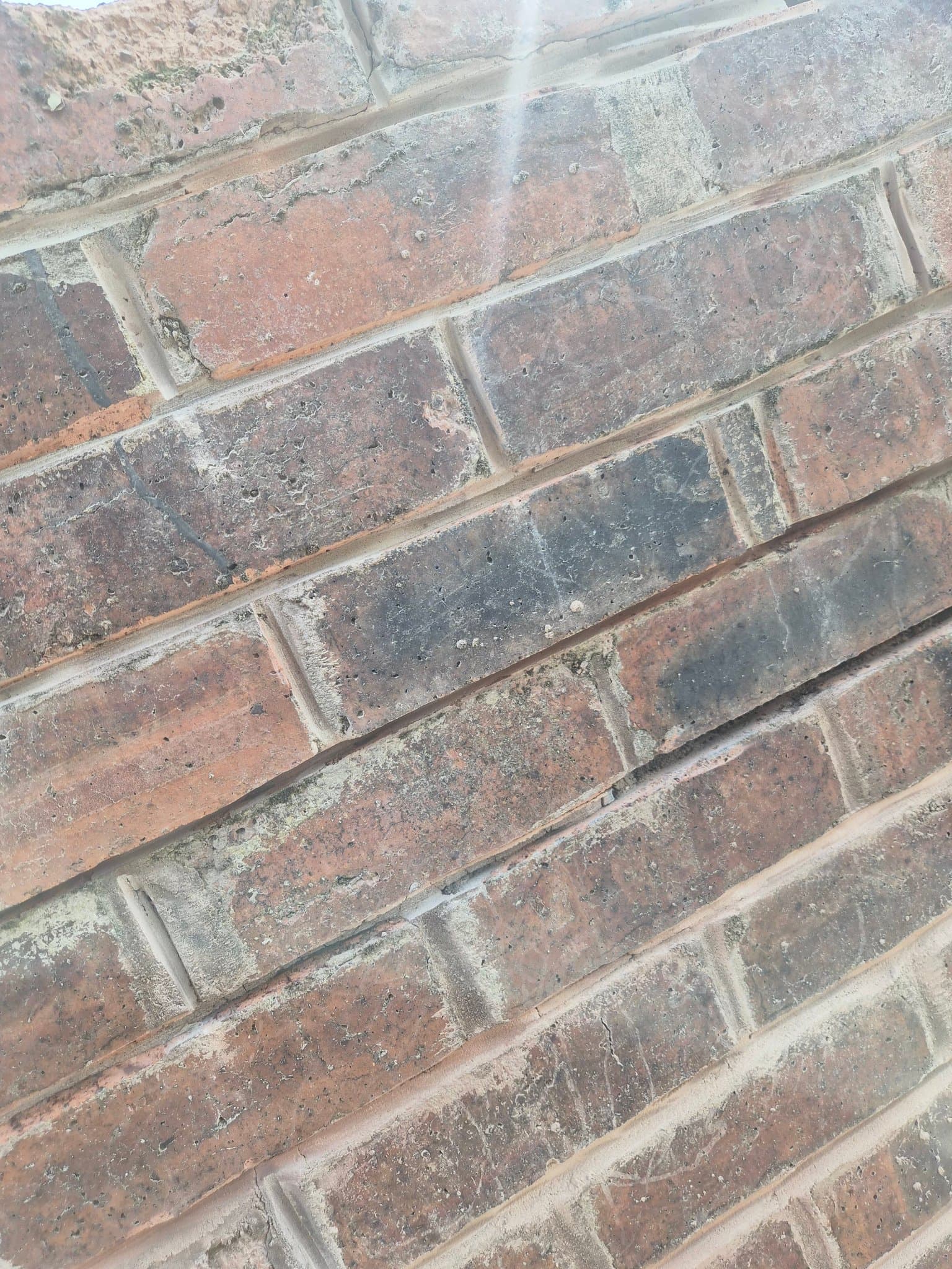 Close-up of fresh repointing between weathered bricks on a chimney stack