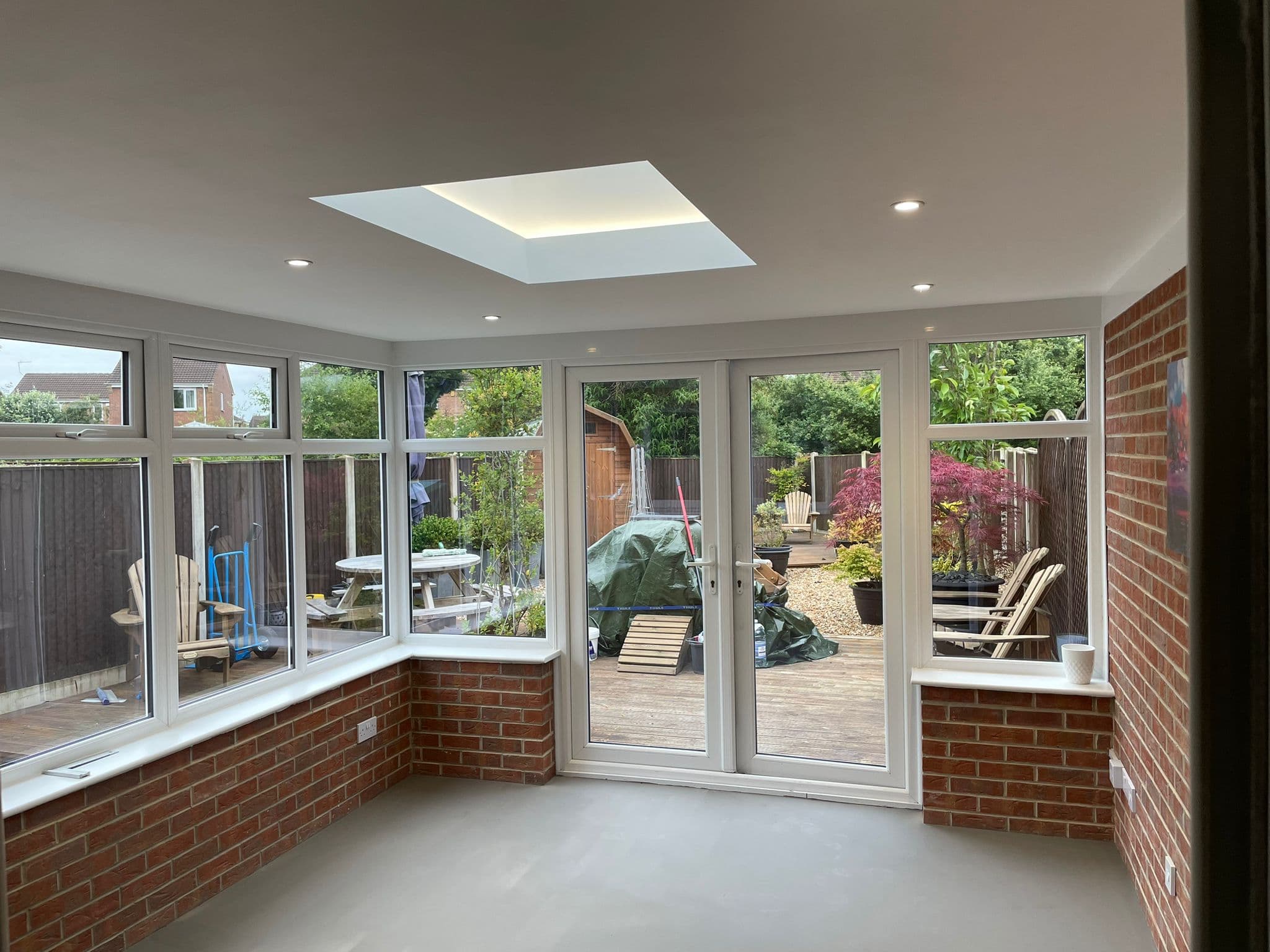 Conservatory interior with a flush skylight in the new plastered ceiling and French doors to the garden